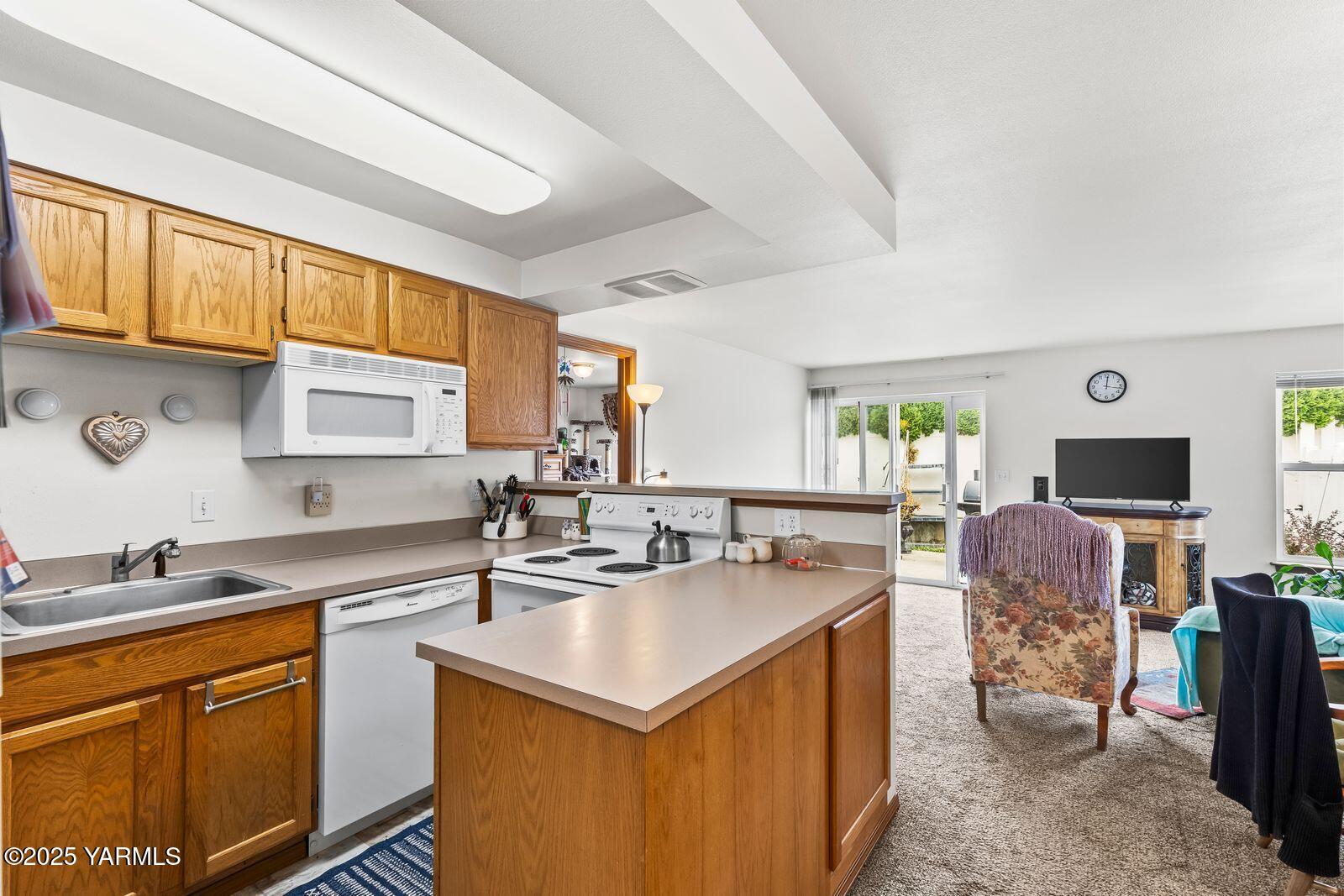 105 Peach Tree Lane, Unit 3 Yakima, WA 98908 - Photo 5 of 21 a kitchen that has a sink a stove counter top space and a window in it