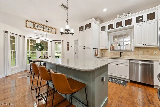 a kitchen with stainless steel appliances granite countertop a sink a stove a refrigerator dining table and chairs