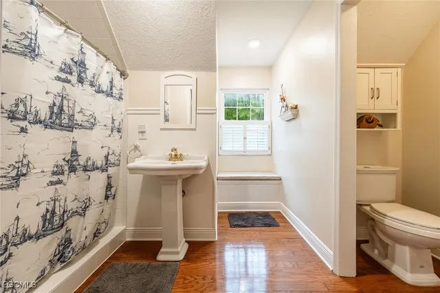 a bathroom with a sink and mirror with toilet