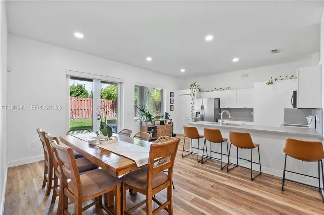 a view of a dining room with furniture a rug and wooden floor