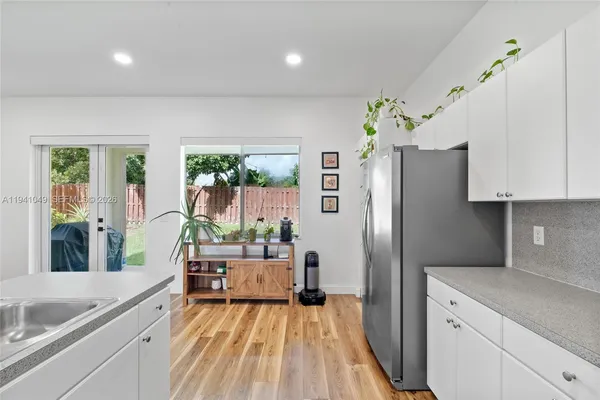 a kitchen with stainless steel appliances kitchen island granite countertop a kitchen island and chairs in it