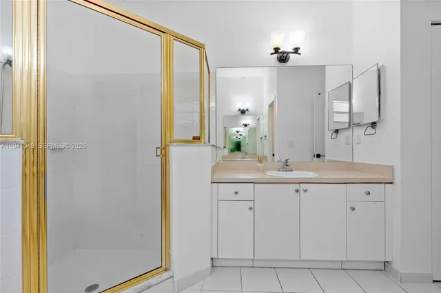 a view of a hallway with wooden floor and a bathroom