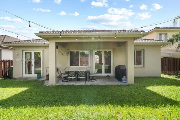 an aerial view of residential houses with outdoor space and trees