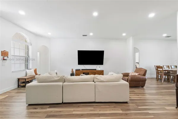 a living room with furniture wooden floor and a flat screen tv