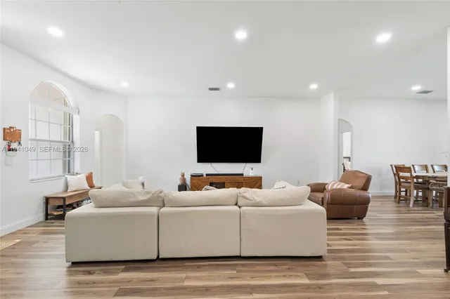 a living room with furniture wooden floor and a flat screen tv