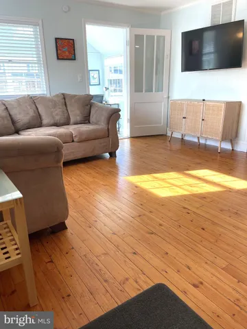 a living room with a flat screen tv a couch and a flat screen tv