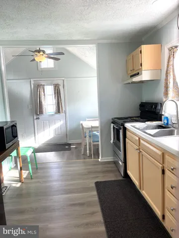 a kitchen with a sink cabinets and wooden floor