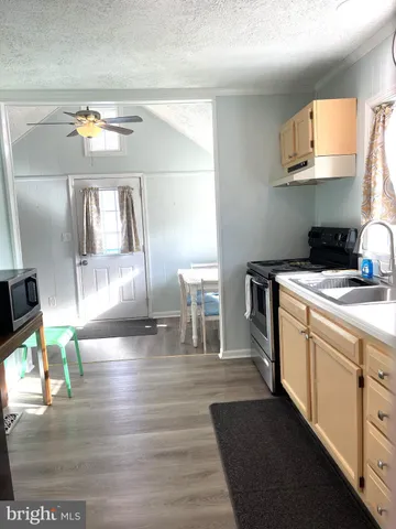 a kitchen with a sink cabinets and a wooden floor