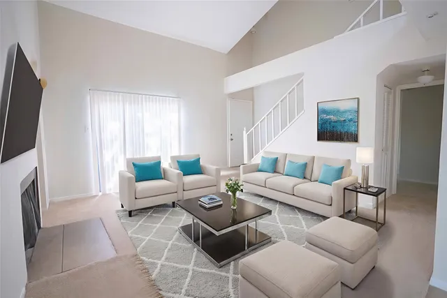 a living room with furniture a flat screen tv and a fireplace