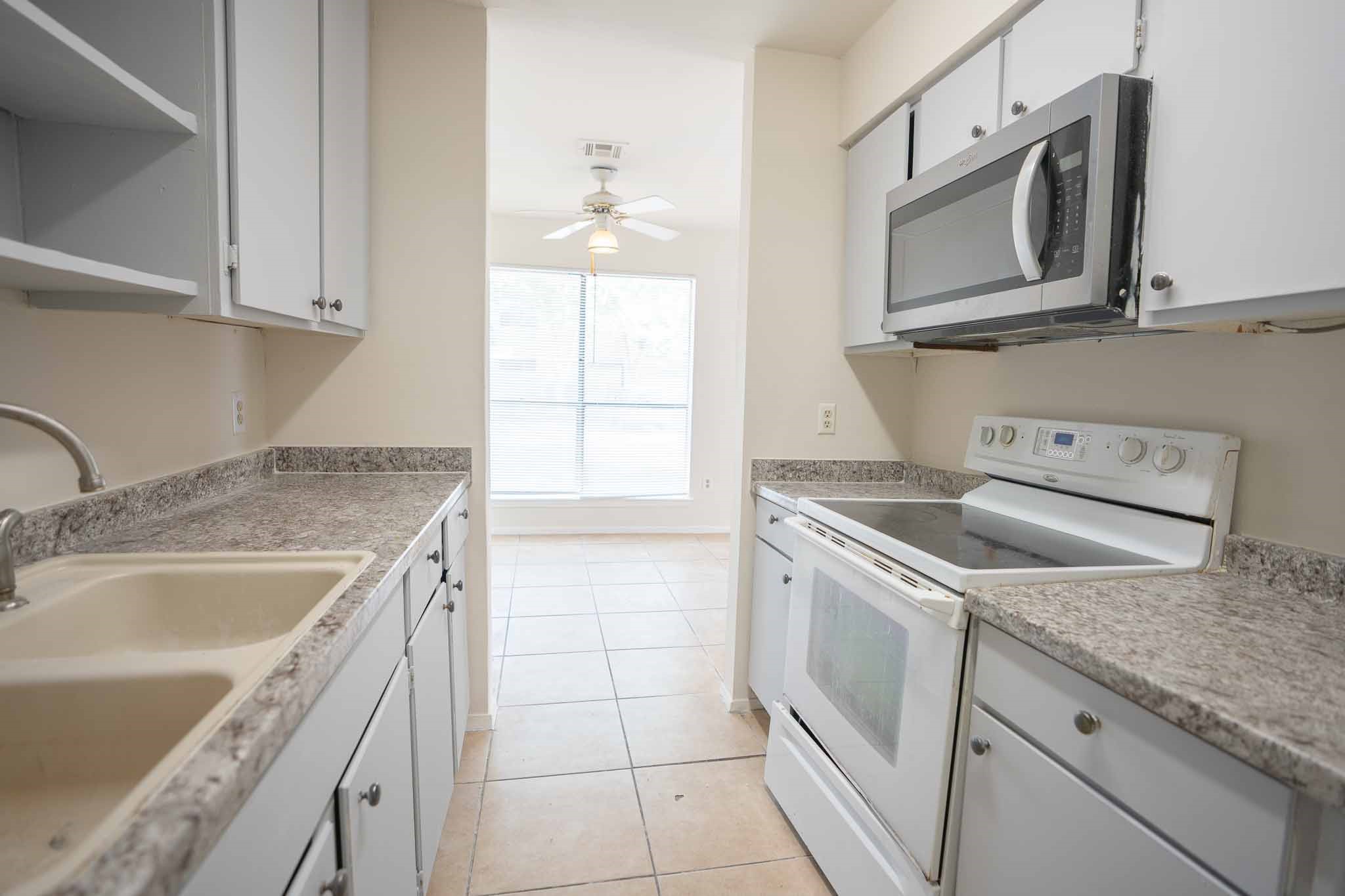 3632 Ocee Street Houston, TX 77063 - Photo 6 of 17 a kitchen with granite countertop a sink stove and microwave