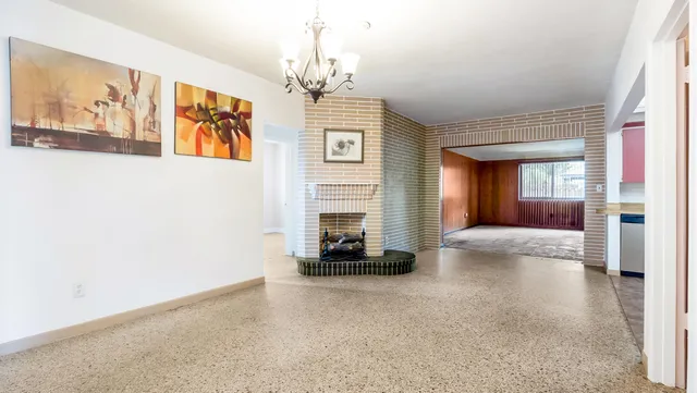 a view of a livingroom with a fireplace a window and a couch