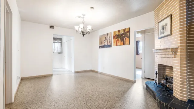 a view of an empty room with furniture and a window