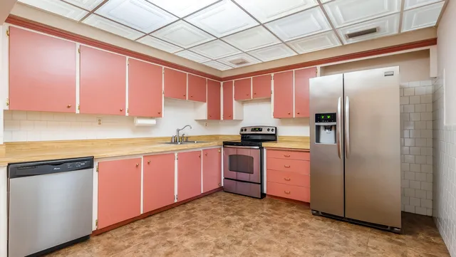 an empty room with windows and cabinet