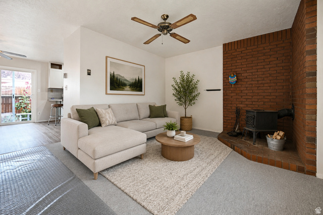 285 West 600 North, Unit 2 Logan, UT 84321 - Photo 2 of 21 Living area featuring a brick accent wall with a wood-burning stove, ceiling f\