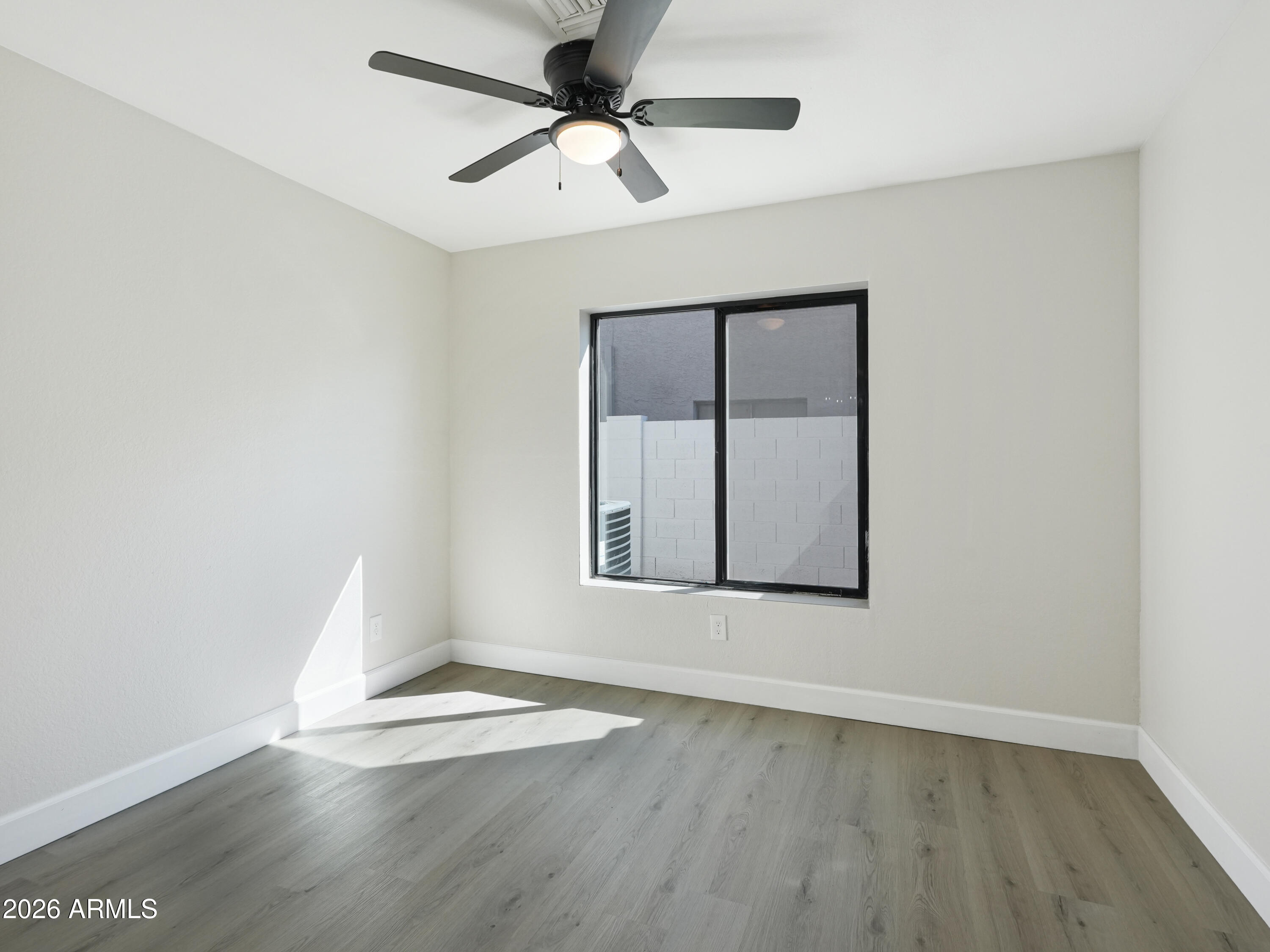 1960 East Krista Way Tempe, AZ 85284 - Photo 23 of 36 an empty room with wooden floor and windows