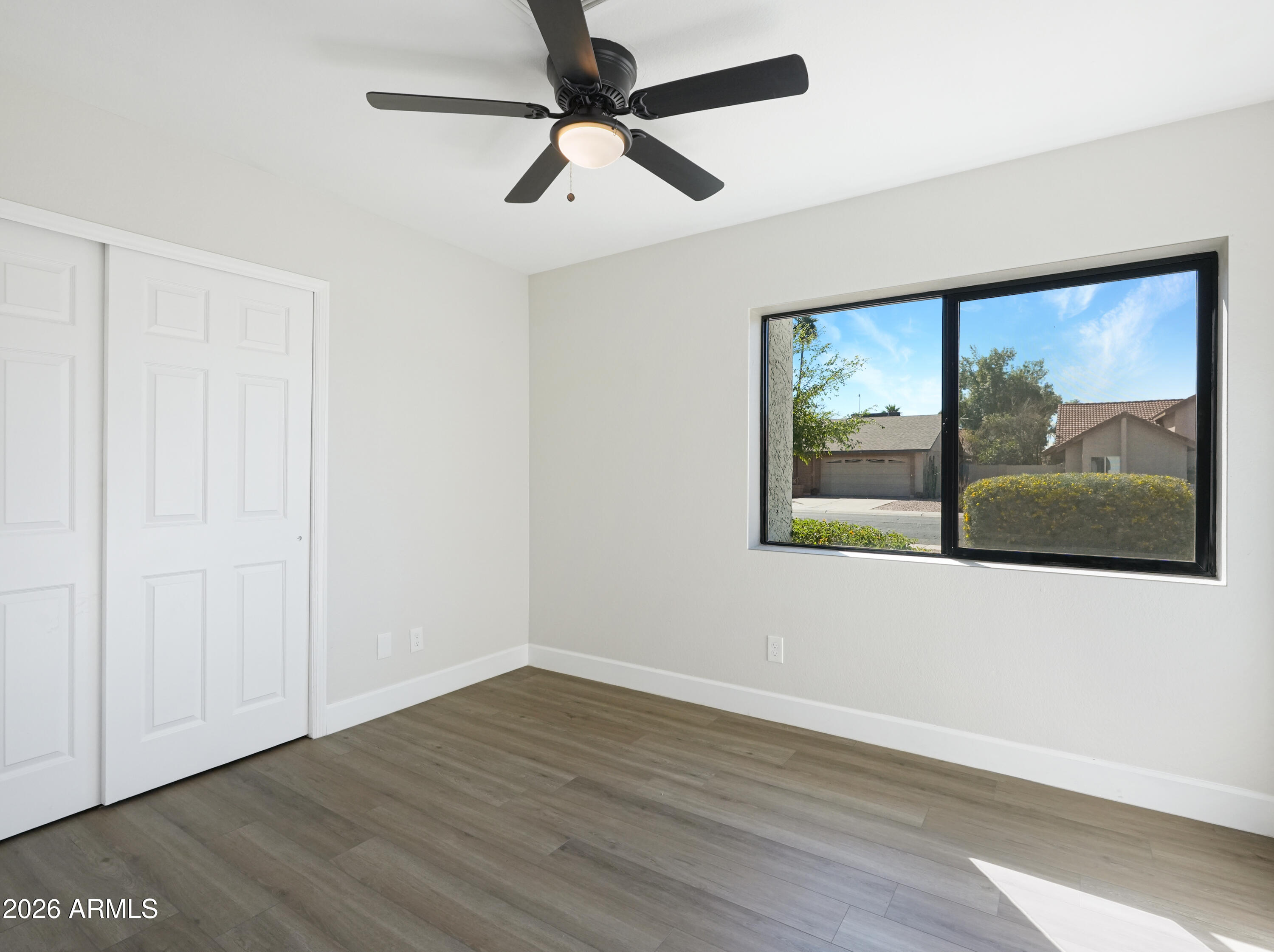 1960 East Krista Way Tempe, AZ 85284 - Photo 25 of 36 an empty room with wooden floor fan and windows