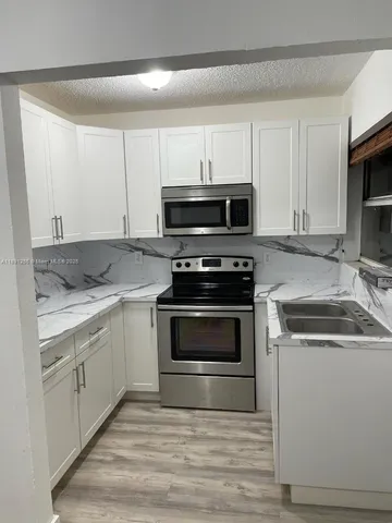 a kitchen with granite countertop a stove and a microwave