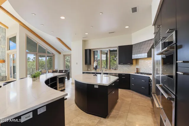 a kitchen with kitchen island granite countertop a sink stove and refrigerator