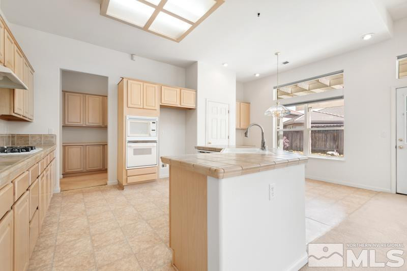 9970 Bandana Way Reno, NV 89521 - Photo 12 of 32 a kitchen with granite countertop a sink and cabinets