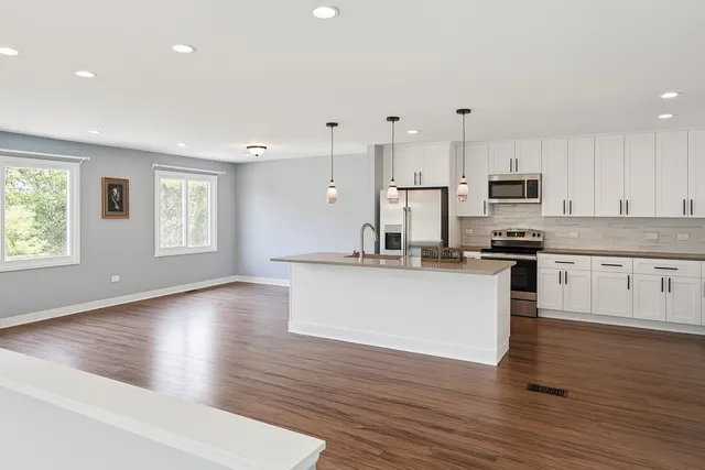 a view of kitchen with granite countertop stainless steel appliances refrigerator sink and cabinets