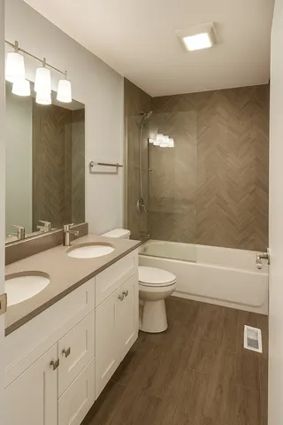 a bathroom with a granite countertop sink a toilet and bathtub