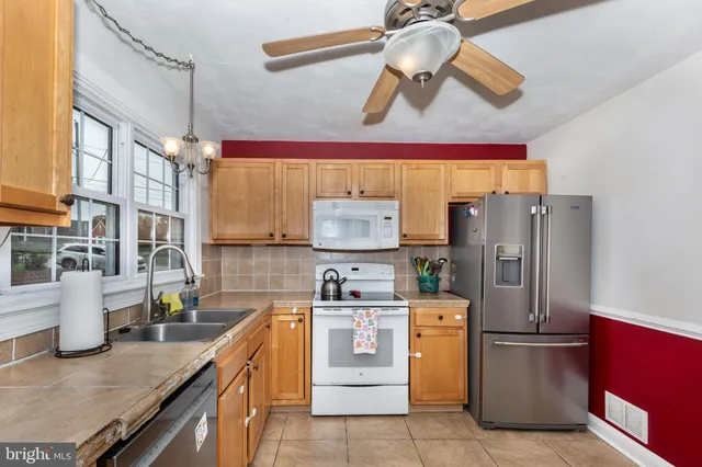 a kitchen with stainless steel appliances granite countertop a sink a stove and a refrigerator