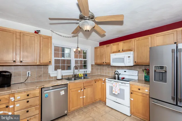 a kitchen with stainless steel appliances a refrigerator sink and cabinets