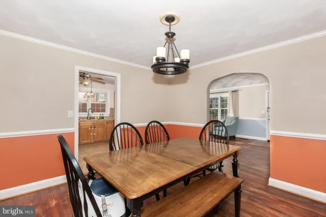 a dining room with furniture a chandelier and wooden floor