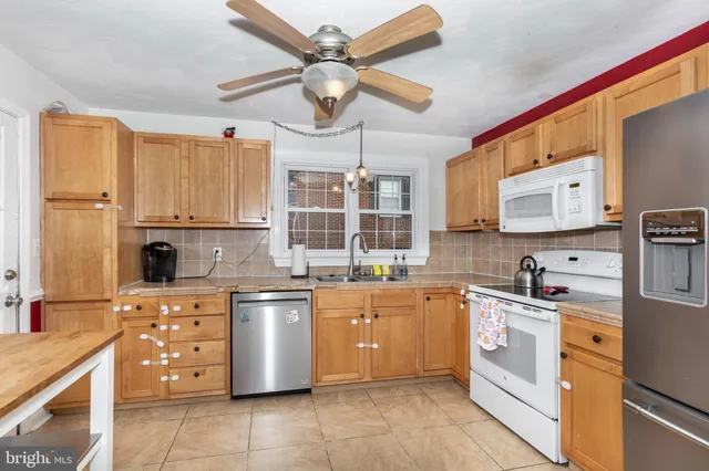 a kitchen with a stove cabinets and white appliances