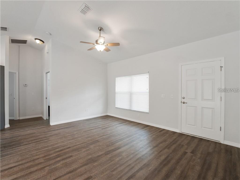 17399 Southwest 25th Circle Ocala, FL 34473 - Photo 12 of 22 an empty room with wooden floor and ceiling fan