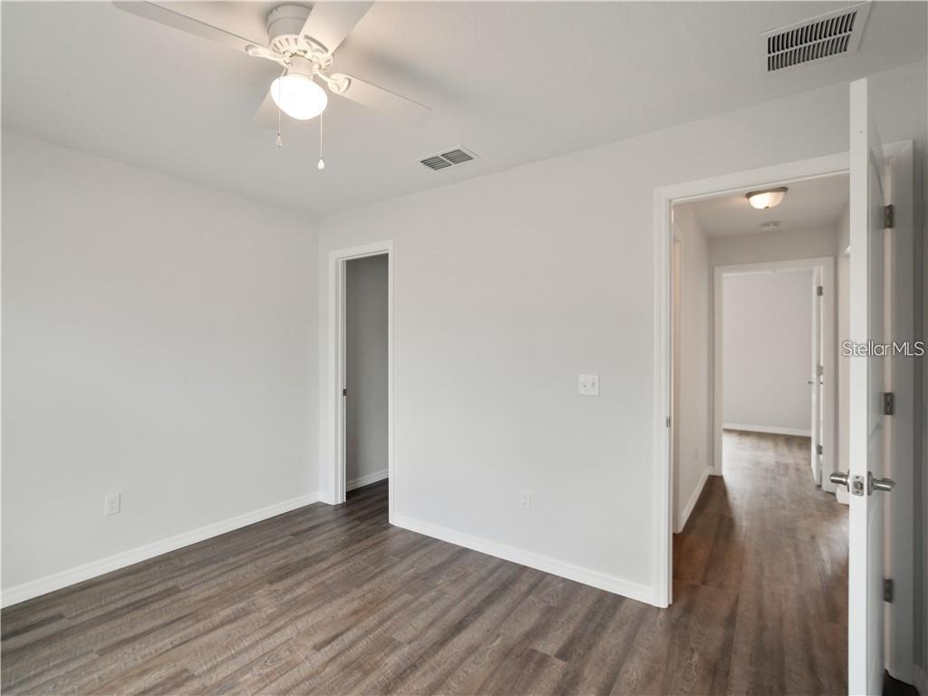 17399 Southwest 25th Circle Ocala, FL 34473 - Photo 14 of 22 an empty room with wooden floor and ceiling fan