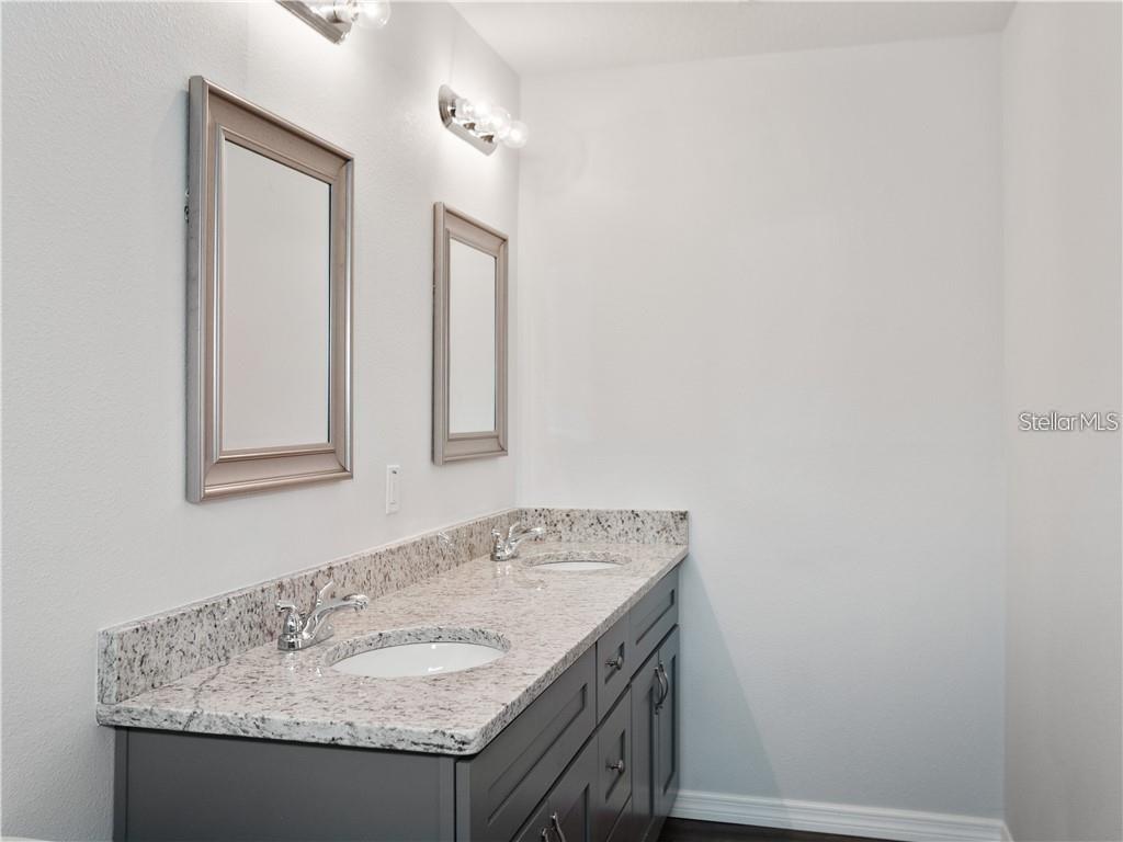 17399 Southwest 25th Circle Ocala, FL 34473 - Photo 17 of 22 a bathroom with a granite countertop sink and a mirror