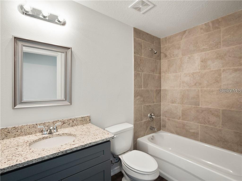 17399 Southwest 25th Circle Ocala, FL 34473 - Photo 21 of 22 a bathroom with a granite countertop bathtub shower sink mirror vanity and toilet