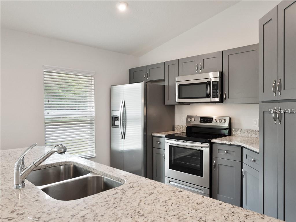 17399 Southwest 25th Circle Ocala, FL 34473 - Photo 4 of 22 a kitchen with a sink a stove and refrigerator