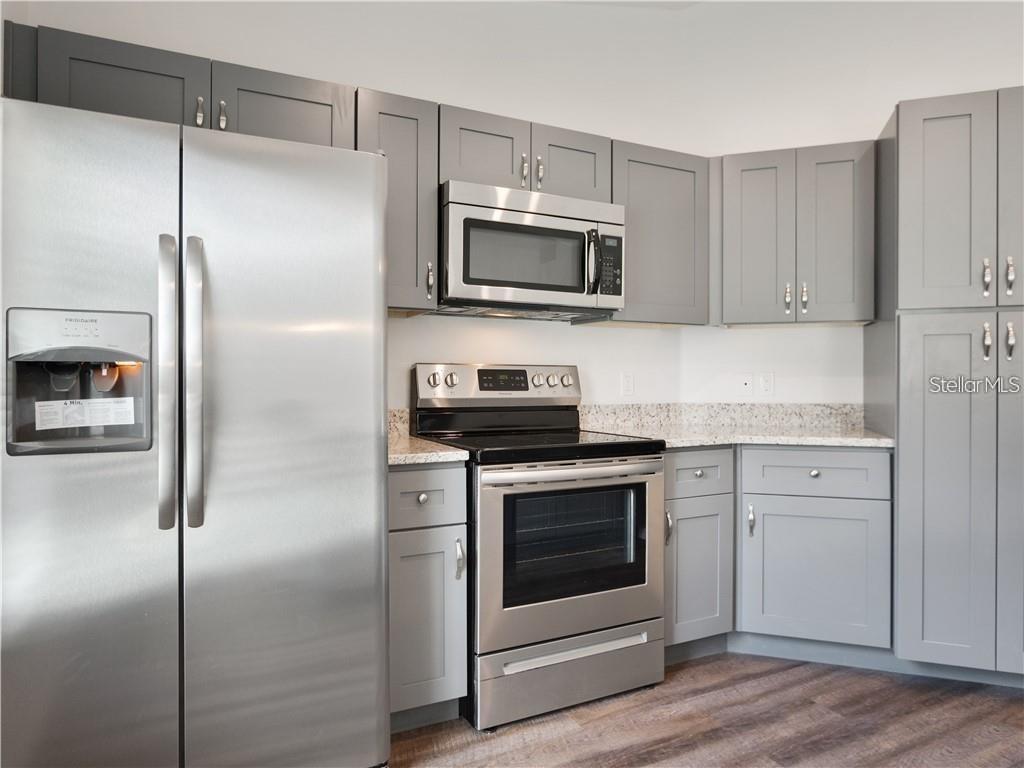 17399 Southwest 25th Circle Ocala, FL 34473 - Photo 5 of 22 a kitchen with cabinets stainless steel appliances and a wooden floor