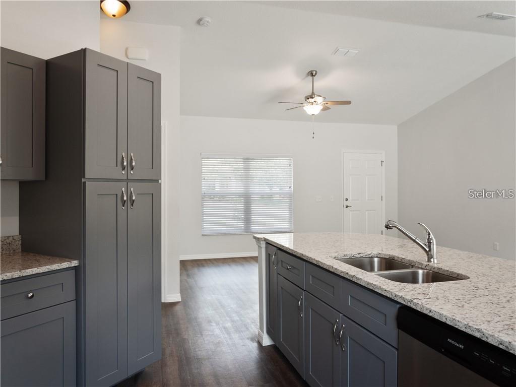 17399 Southwest 25th Circle Ocala, FL 34473 - Photo 7 of 22 a kitchen with a sink dishwasher a refrigerator and cabinets
