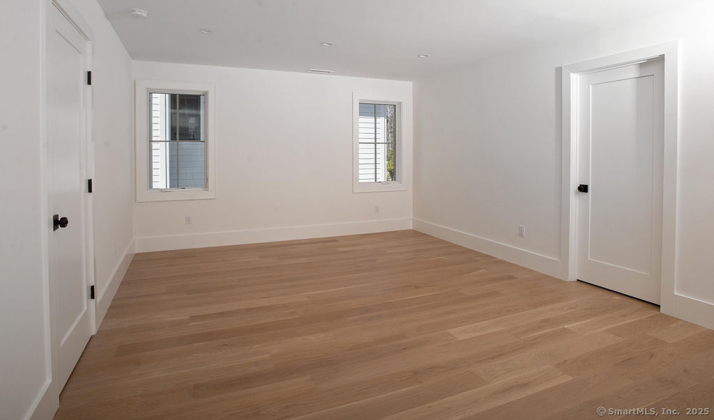 6 Down River Road, Unit B New Canaan, CT 06840 - Photo 12 of 31 a view of an empty room with wooden floor and a window