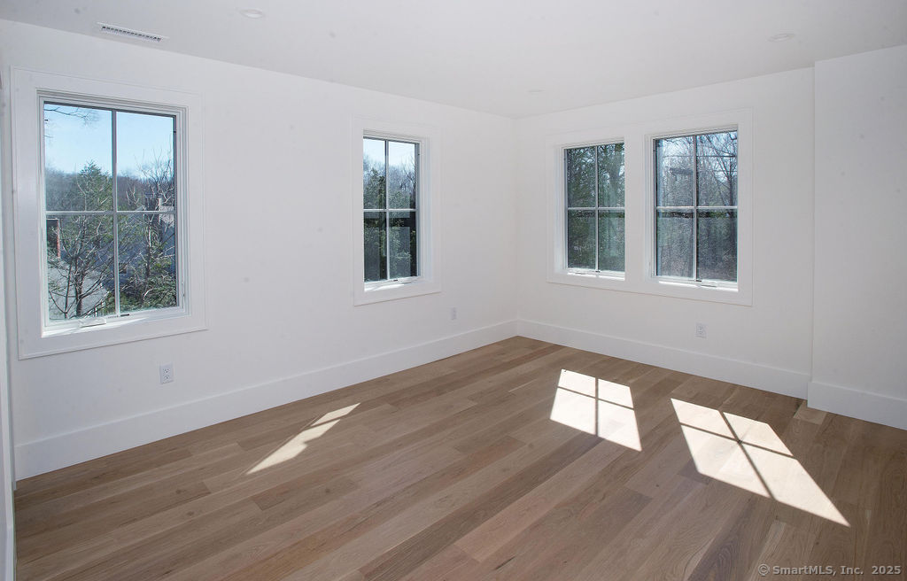 6 Down River Road, Unit B New Canaan, CT 06840 - Photo 20 of 31 a view of an empty room with wooden floor and a window