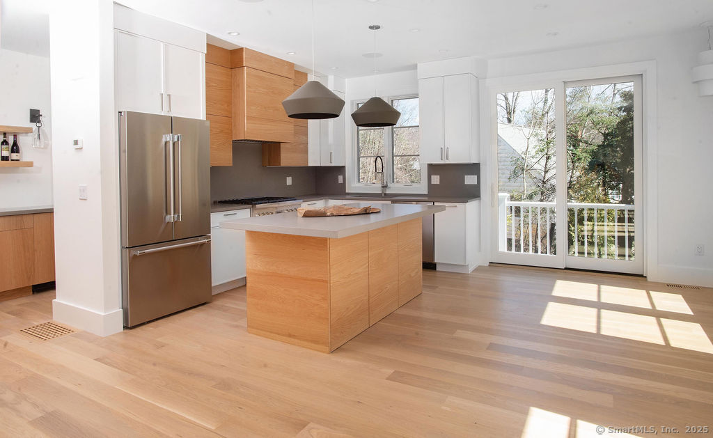 6 Down River Road, Unit B New Canaan, CT 06840 - Photo 2 of 31 a kitchen with stainless steel appliances a stove a refrigerator a sink and white cabinets with wooden floor