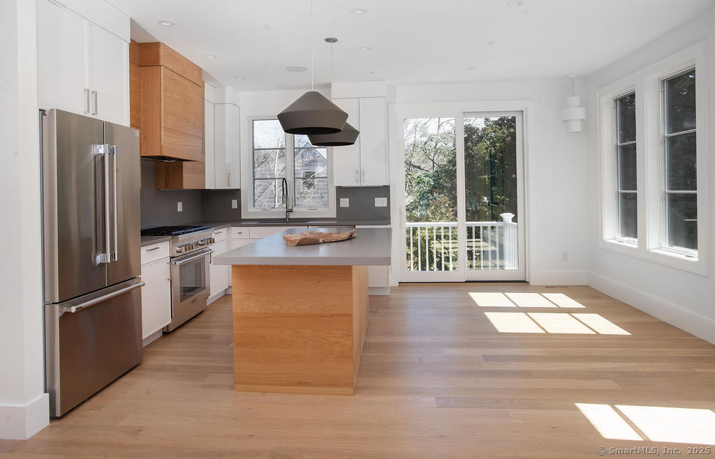 6 Down River Road, Unit B New Canaan, CT 06840 - Photo 4 of 31 a kitchen with stainless steel appliances granite countertop a stove a refrigerator and a fireplace