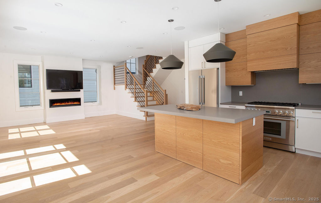 6 Down River Road, Unit B New Canaan, CT 06840 - Photo 6 of 31 a kitchen with stainless steel appliances a stove a microwave and wooden floor