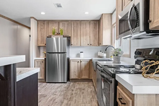a kitchen with stainless steel appliances granite countertop a refrigerator stove and sink