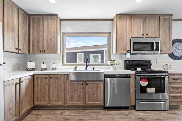 a kitchen with stainless steel appliances granite countertop a stove a sink and a microwave