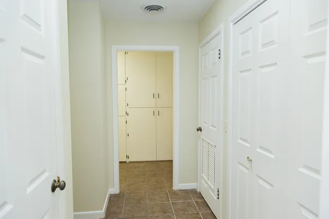 an empty room with closet and a chandelier fan