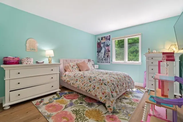 a bedroom with a bed and a dresser in it