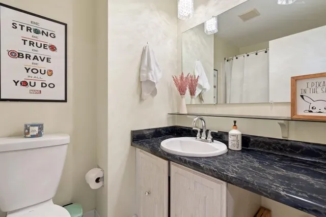 a bathroom with a sink a toilet and a mirror