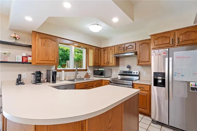 a kitchen with stainless steel appliances granite countertop a sink stove and refrigerator