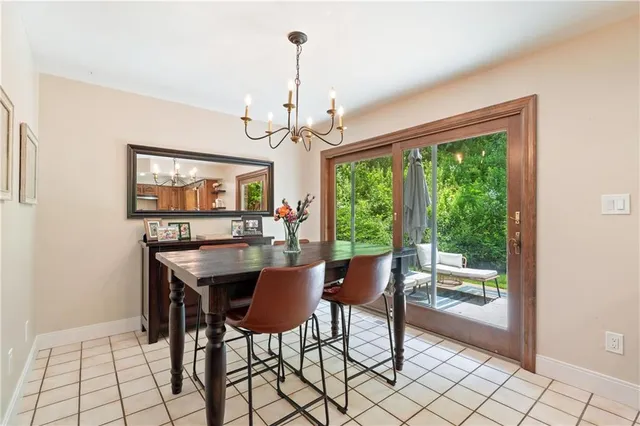 a dining room with chandelier a glass table and chairs