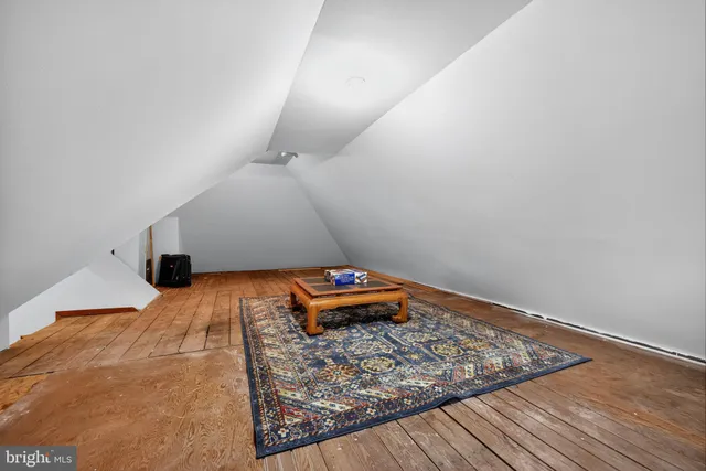 a room with a bed and a wooden floor