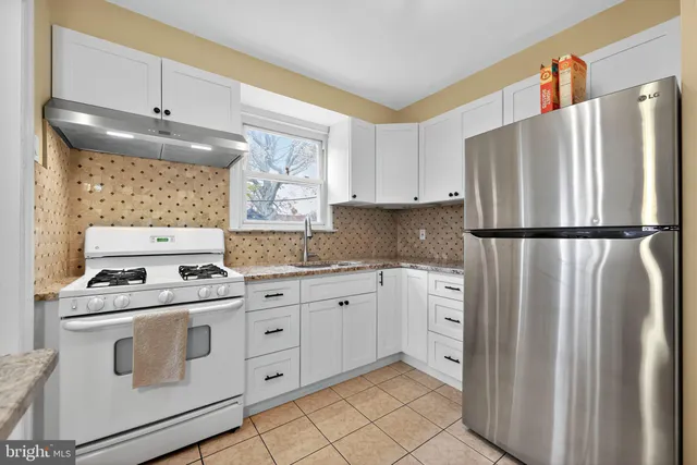 a kitchen with white cabinets and white appliances